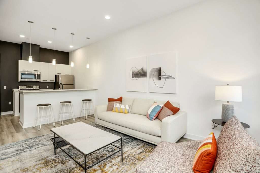 Living room with a large area rug, coffee table, and neutral colored furniture