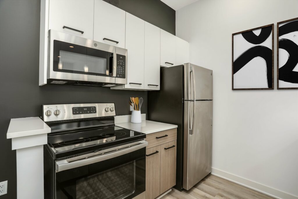 Kitchen corner with stainless steel appliances, modern cabinets, and hardwood-style floors