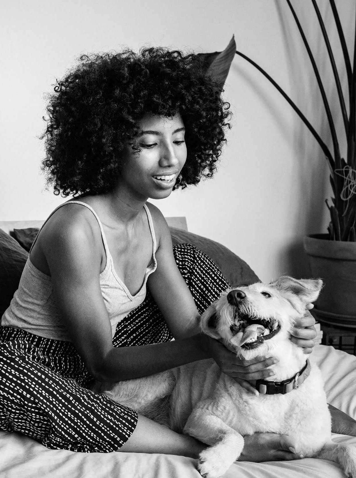 Women sitting on couch petting a dog